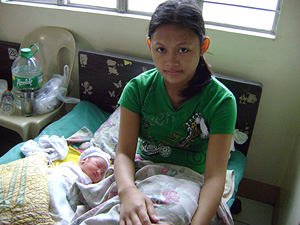 A 16-year-old sits beside her newborn baby. This is her second child Ana Santos IRIN